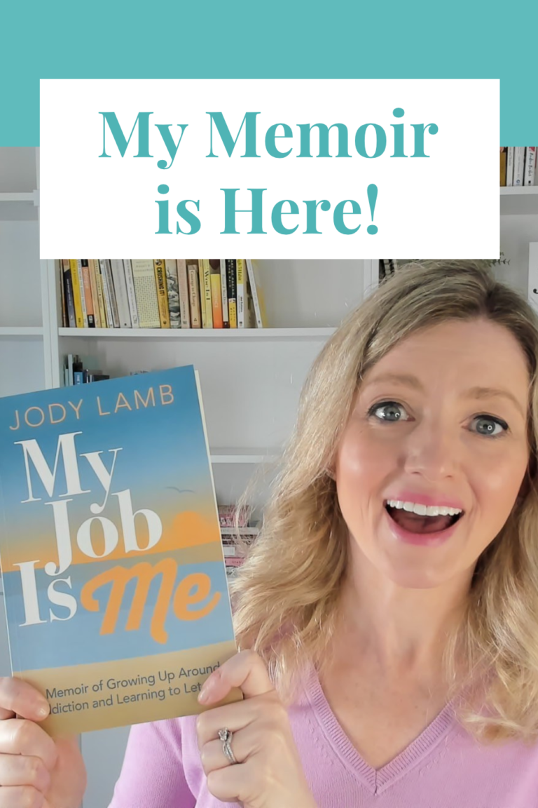Author Jody Lamb smiling and holding up her memoir, My Job is Me